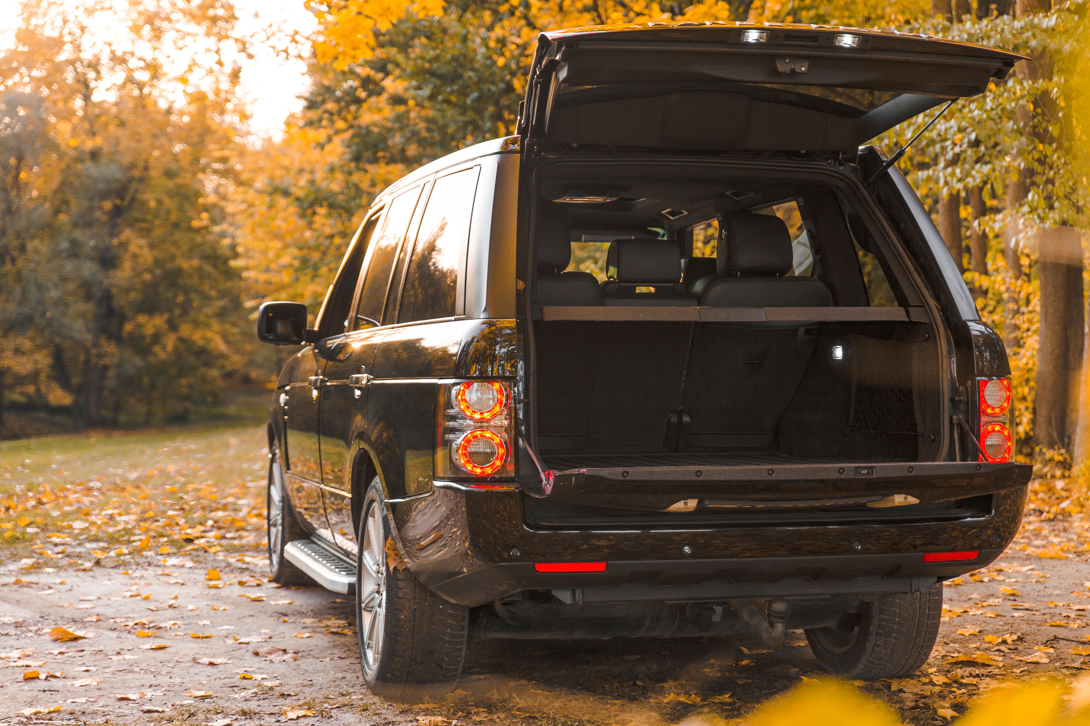 Black SUV parked on a forest road, illustrating a vehicle ownership decision.